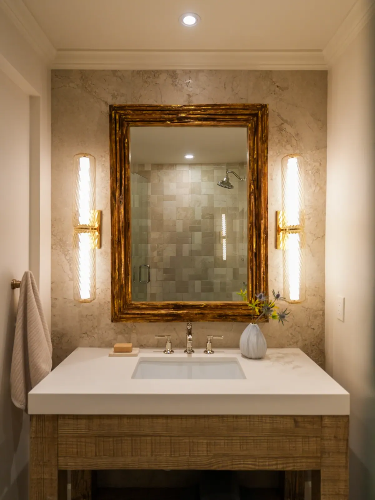 Warm stone vanity with a gilded mirror