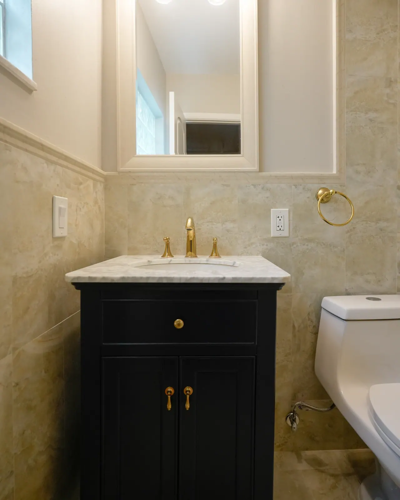 Navy vanity with a marble top and gold faucet