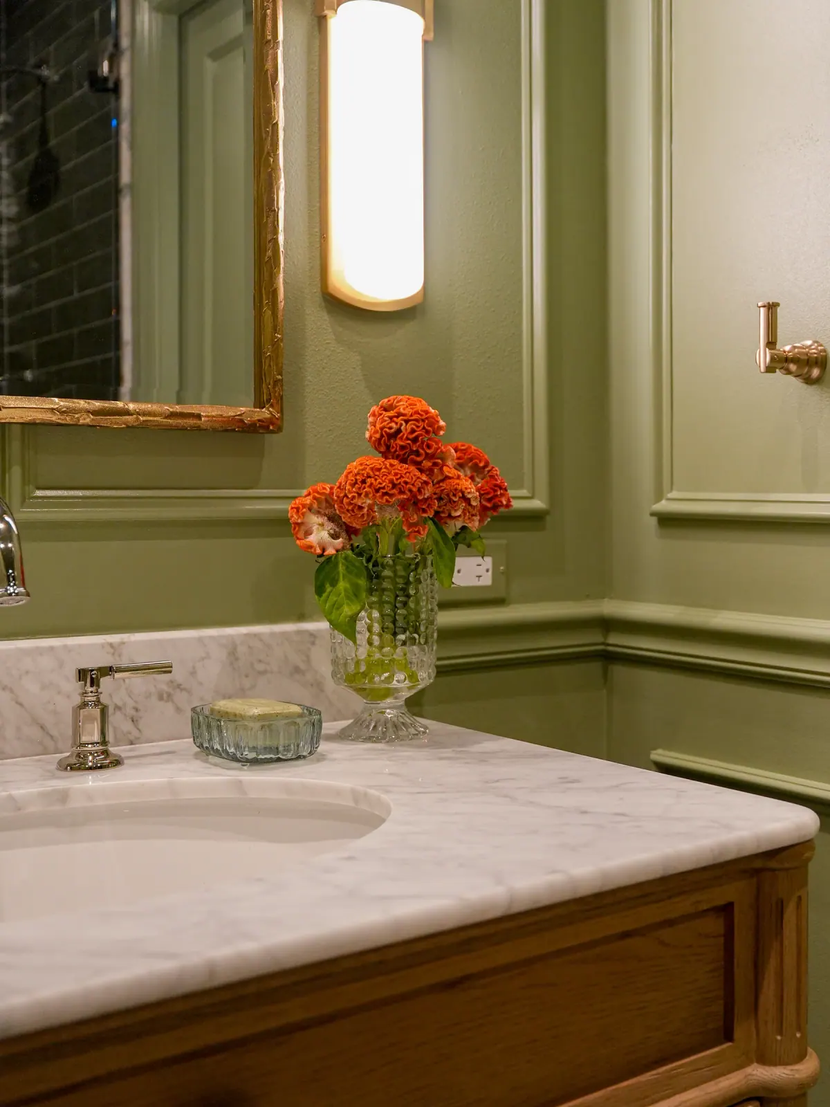 Marble vanity top against olive wainscoting