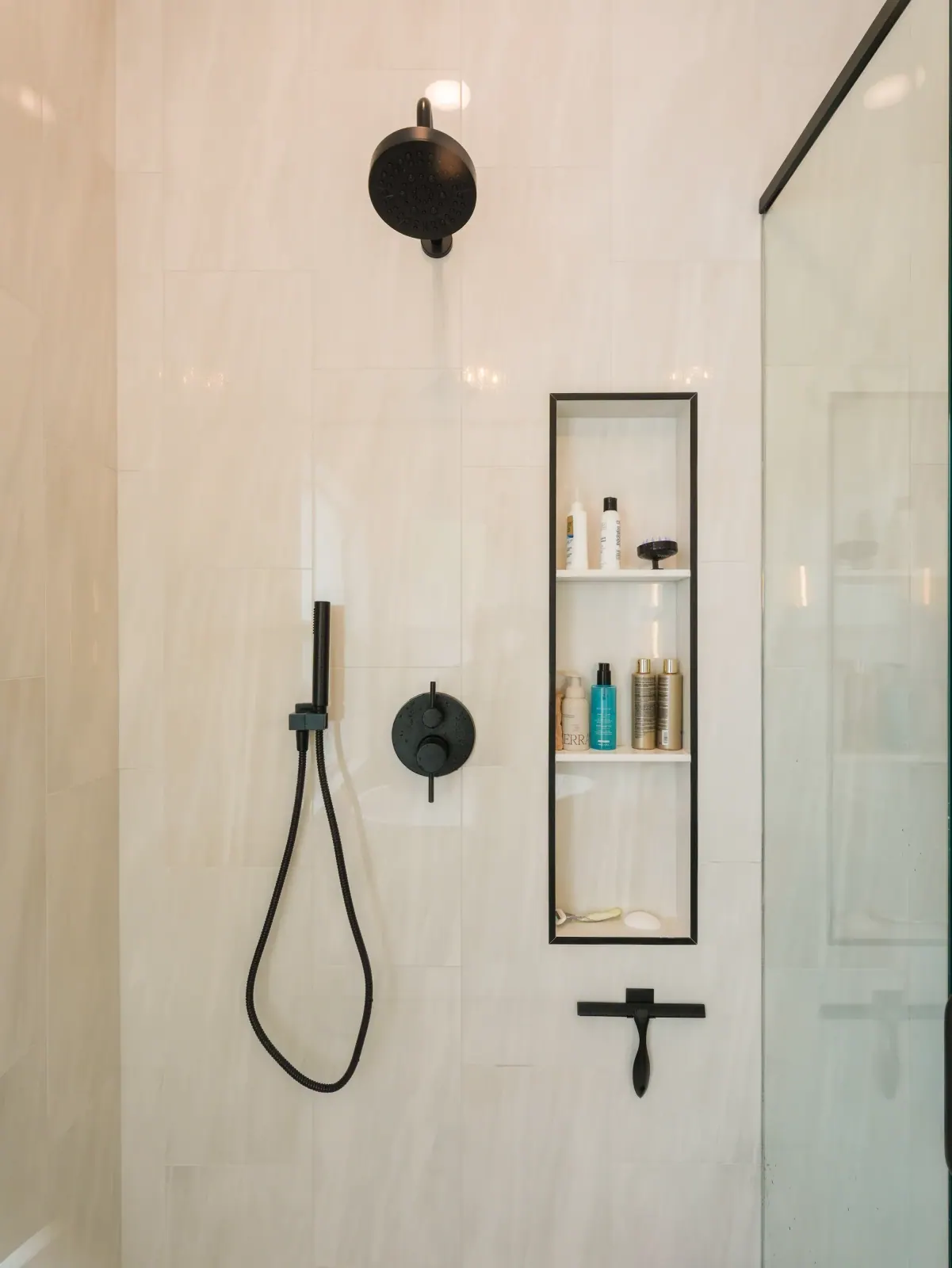 Plaster-finish shower with a tall niche and black fixtures