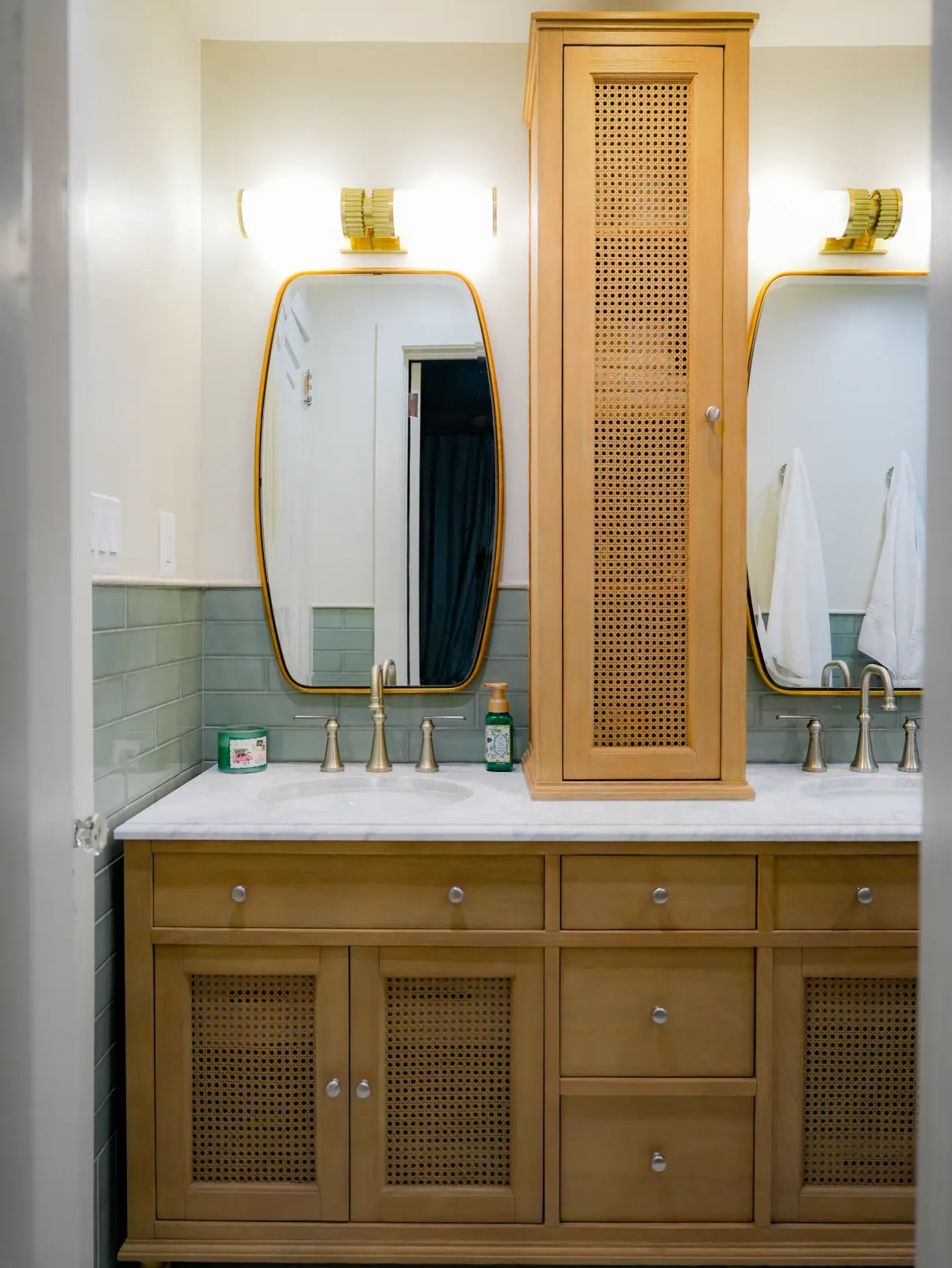 Double vanity with gold-framed mirrors and a cane tower