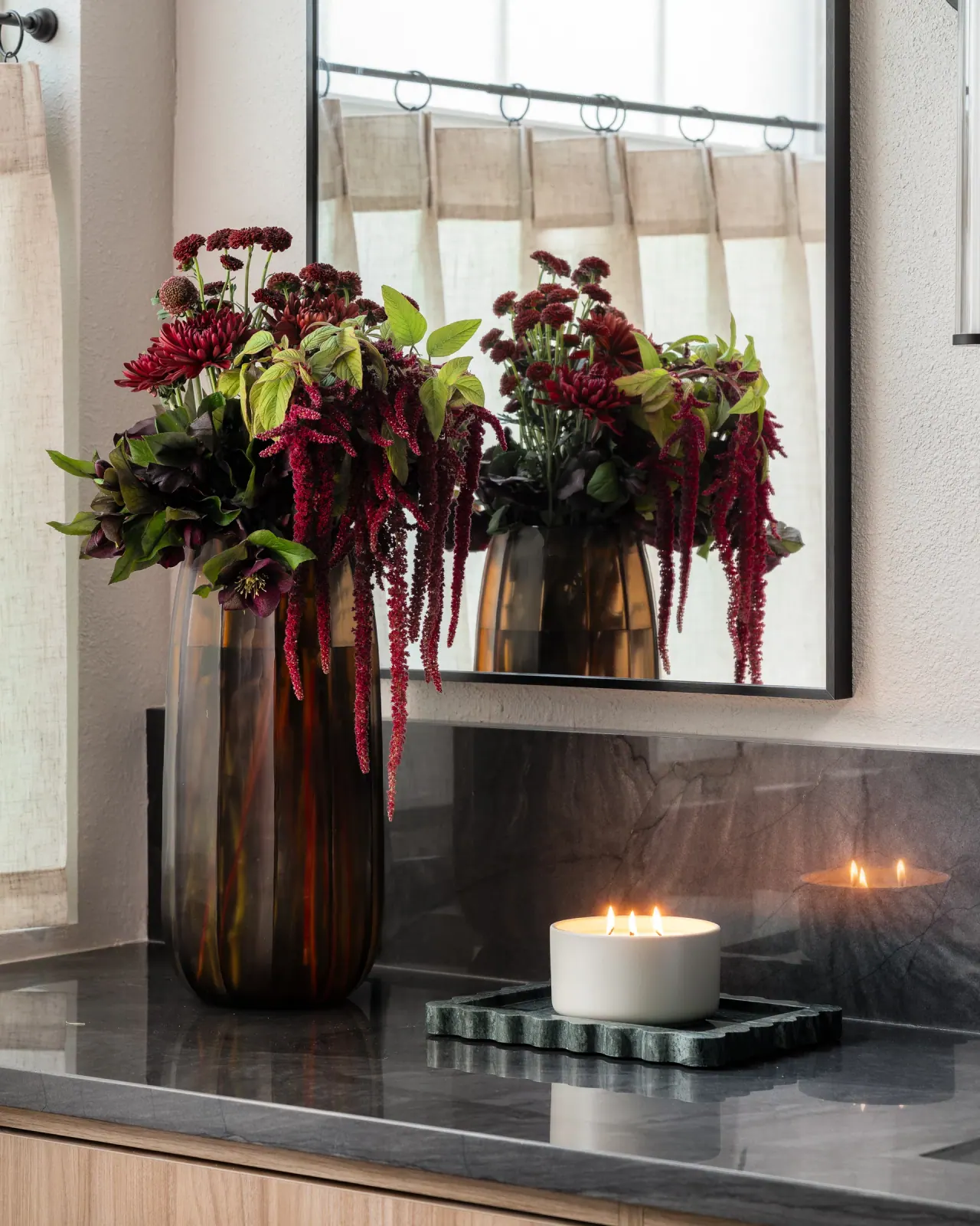 Dark stone vanity top styled with flowers and a candle