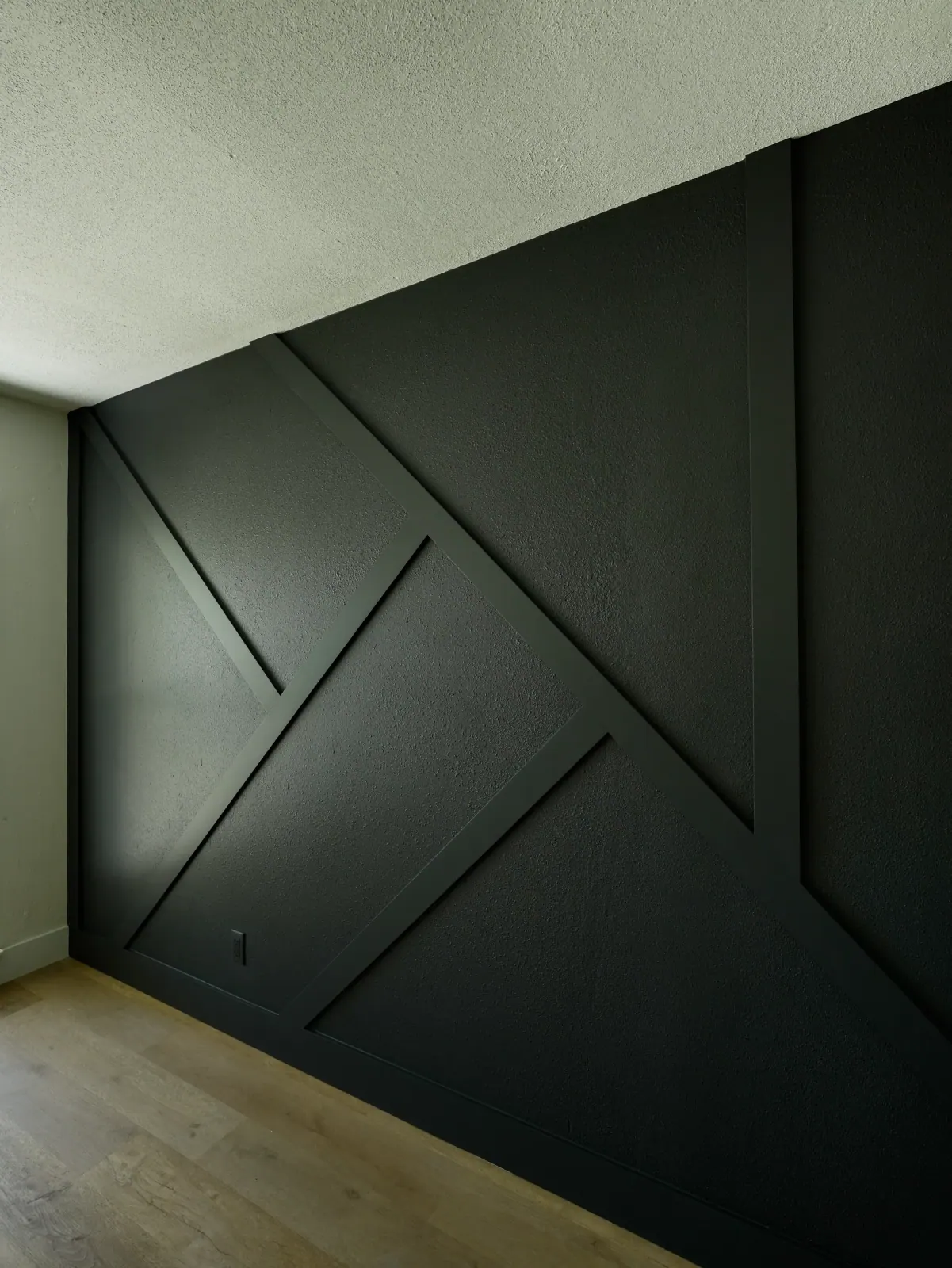 Geometric trim detail on a forest green wall