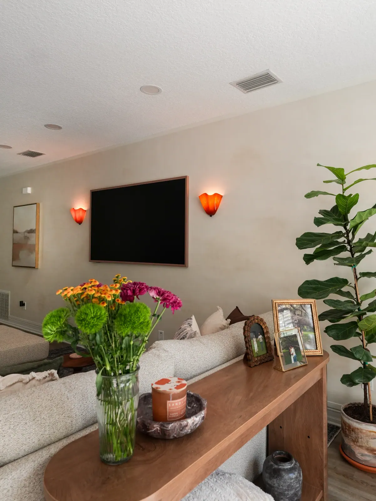 Limewash wall with brass sconces and flowers