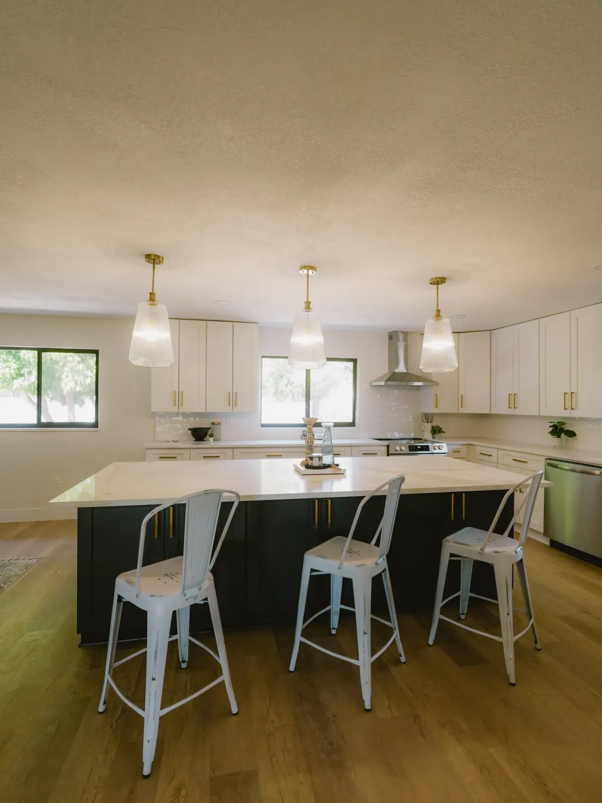 Navy island with counter stools under glass pendants