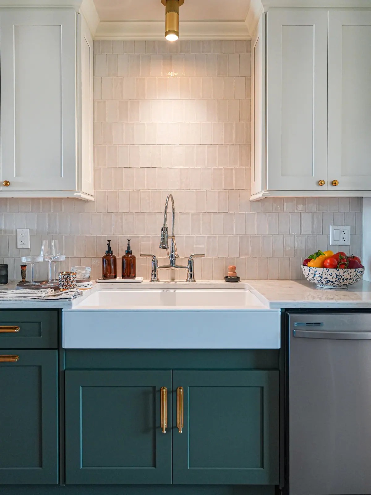 Teal lower cabinets with a farmhouse sink and zellige tile