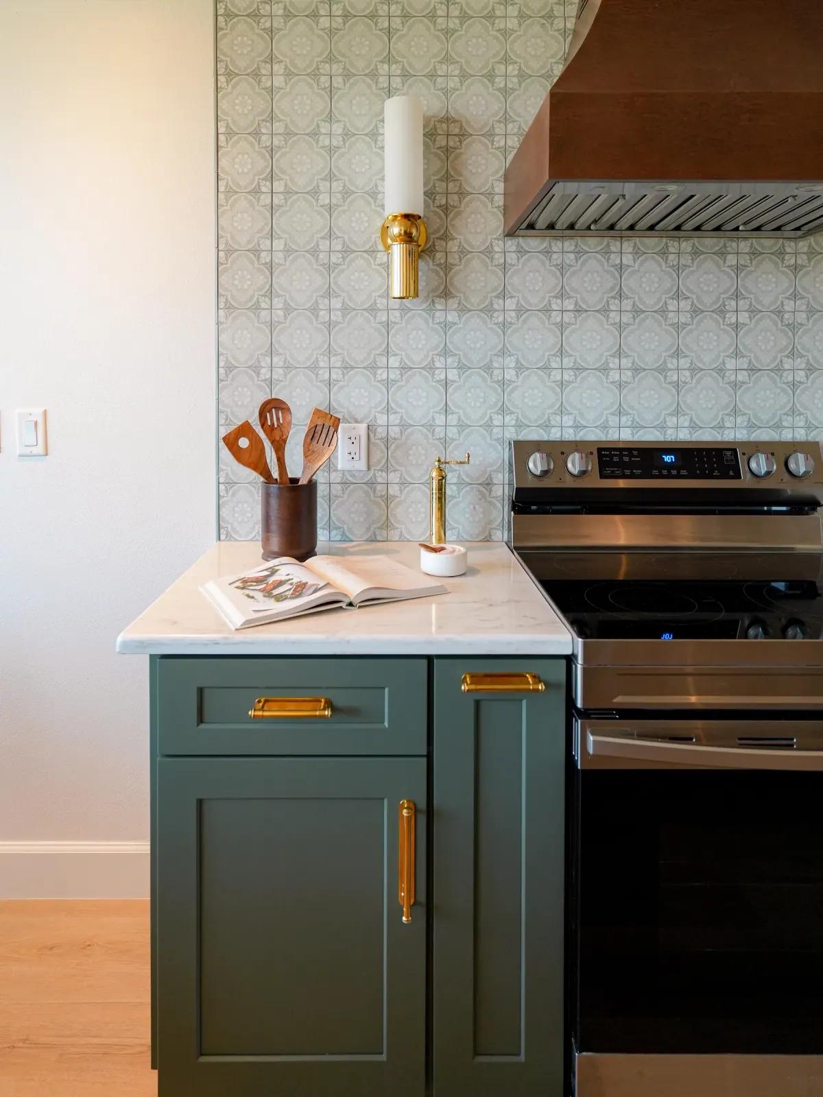 Teal cabinetry beside the range with patterned tile backsplash