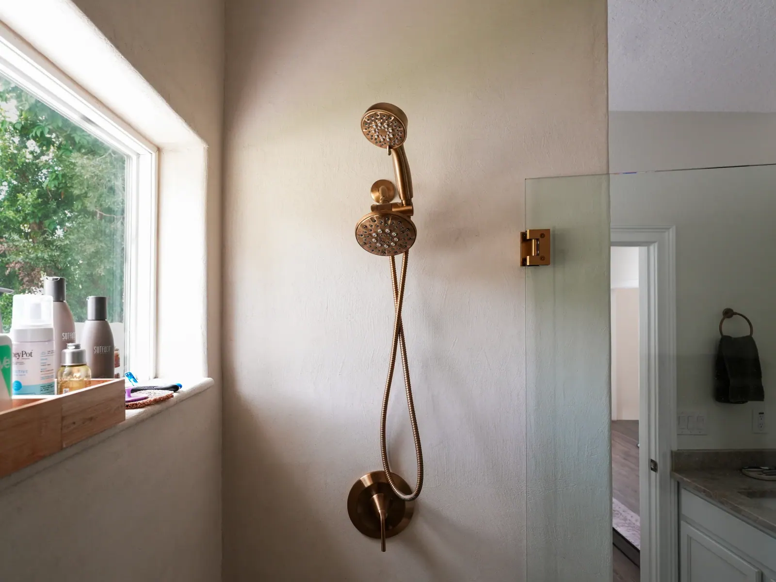Brass shower fixtures on a seamless microcement wall