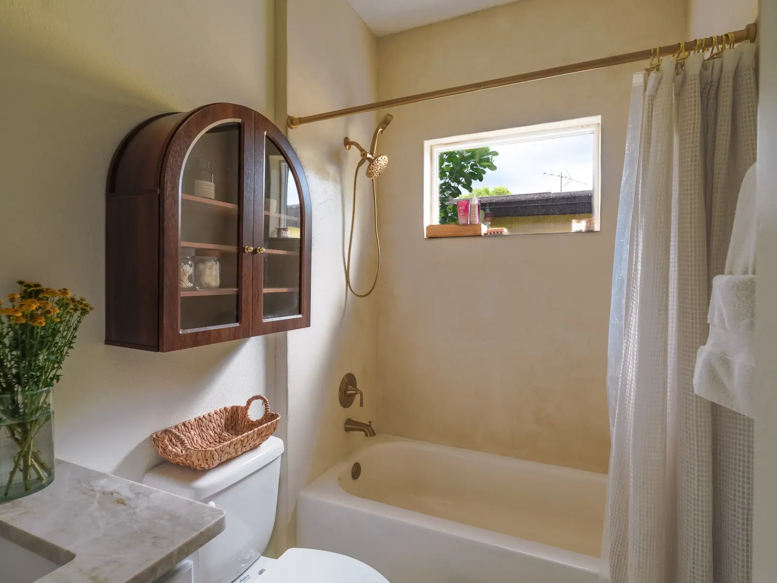 Seamless microcement walls around a tub, under a window